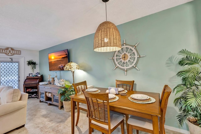 tiled dining space with a textured ceiling