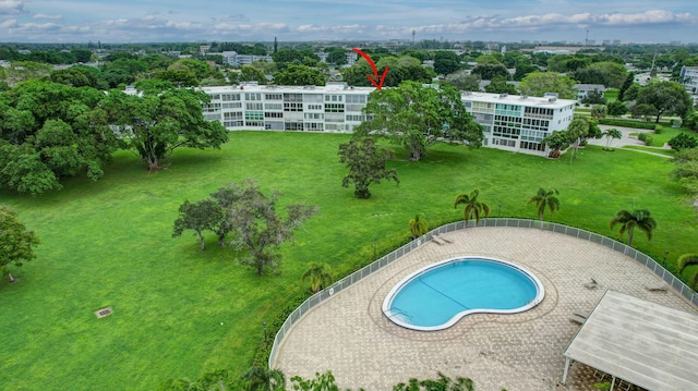 view of pool with a patio and a lawn