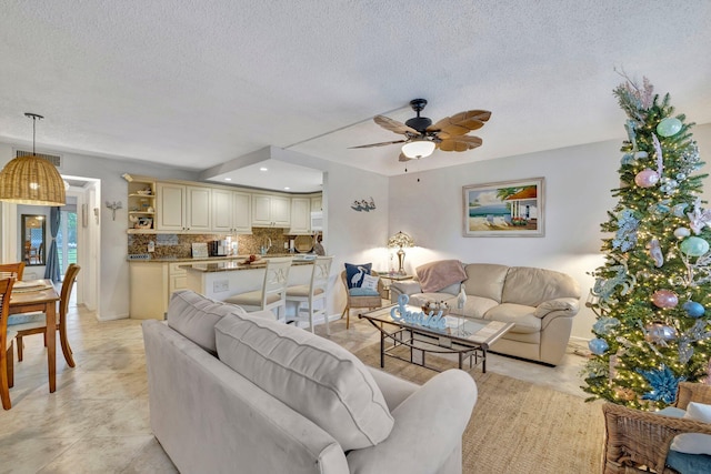 tiled living room featuring a textured ceiling and ceiling fan