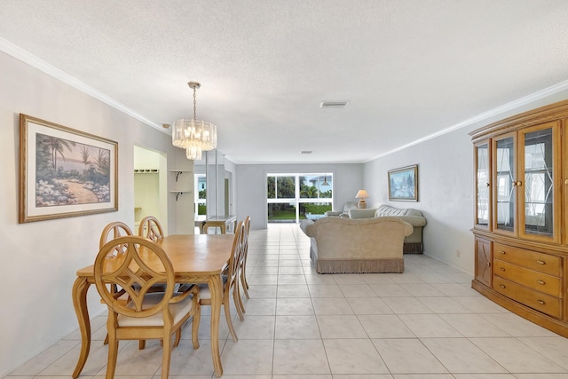 tiled dining room featuring a notable chandelier, a textured ceiling, and ornamental molding