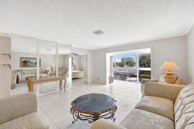 living room featuring a textured ceiling, ornamental molding, and light tile patterned flooring