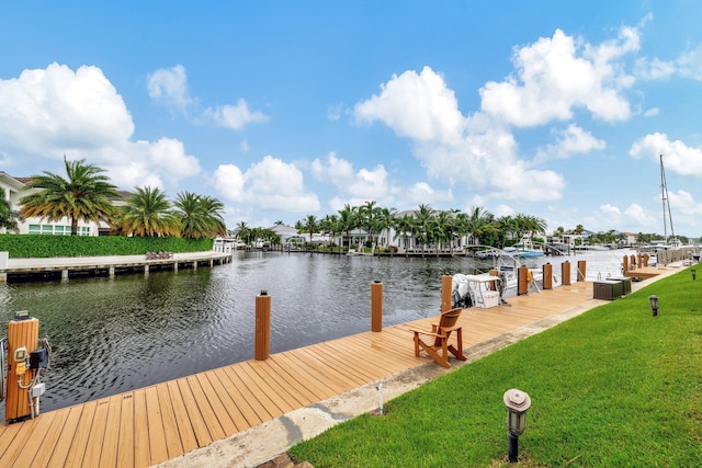 dock area with a water view and a lawn