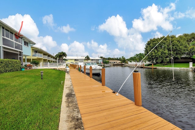 dock area with a lawn and a water view