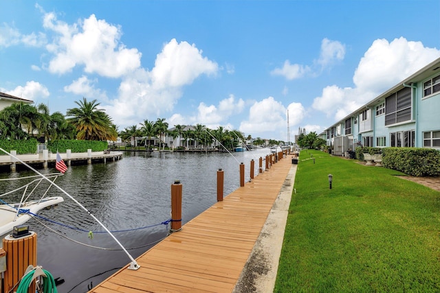 dock area with a lawn and a water view