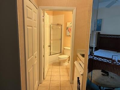 full bathroom featuring vanity, tile patterned floors, combined bath / shower with glass door, and toilet