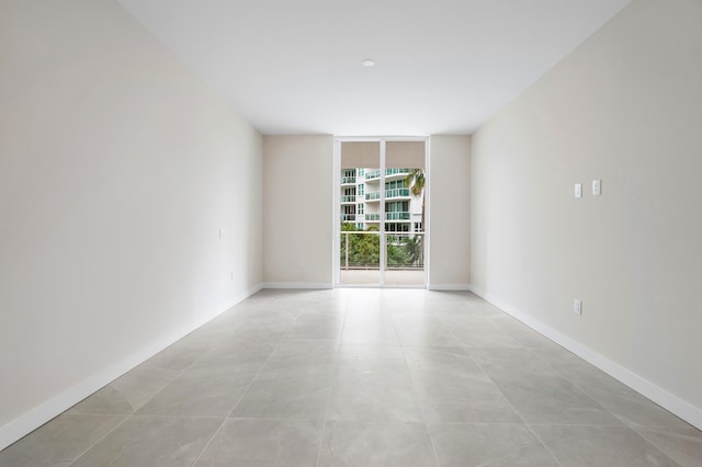 empty room featuring expansive windows and light tile patterned floors