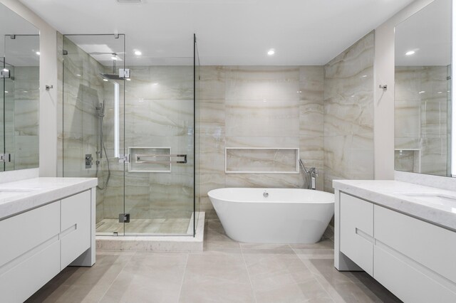 bathroom with tile walls, vanity, and plus walk in shower