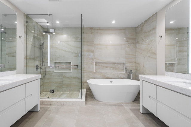 bathroom with vanity, separate shower and tub, and tile walls