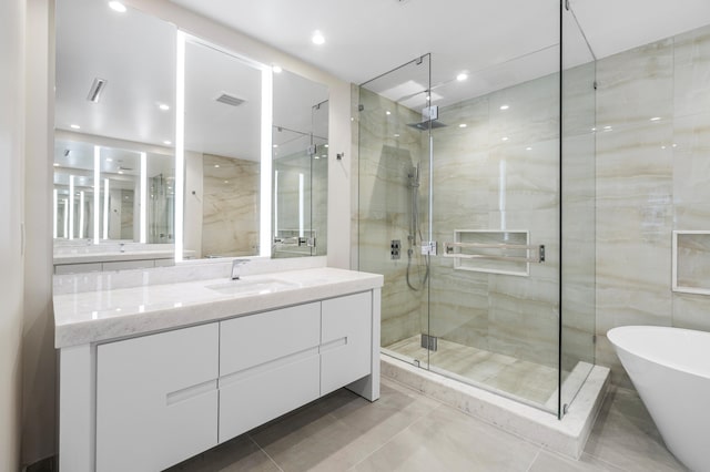 bathroom featuring shower with separate bathtub, tile walls, and vanity