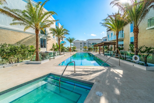 view of swimming pool featuring a hot tub and a patio