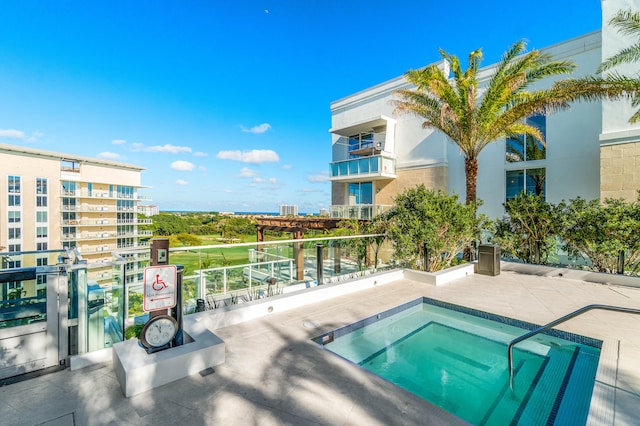 view of swimming pool with a hot tub