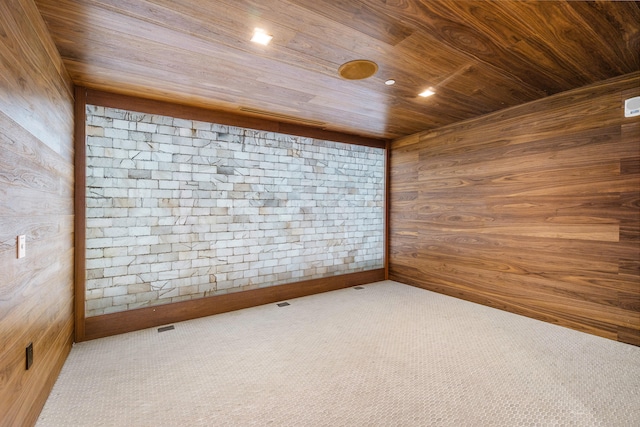 carpeted empty room featuring wood ceiling