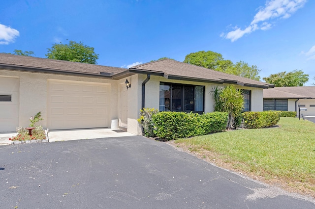 single story home featuring a front yard and a garage