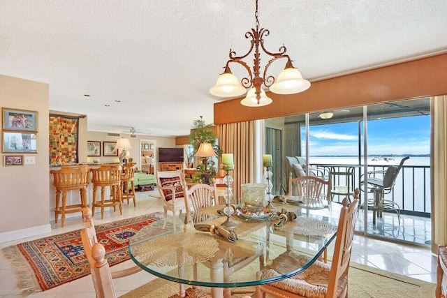 dining space featuring a textured ceiling, ceiling fan with notable chandelier, and light tile patterned floors