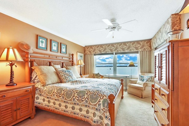 carpeted bedroom featuring ceiling fan and a textured ceiling