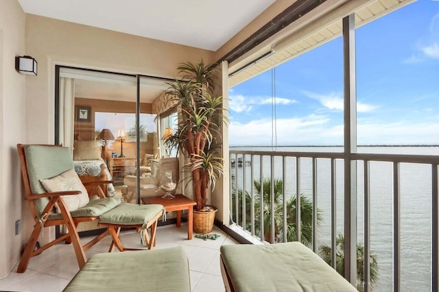 sunroom featuring a water view