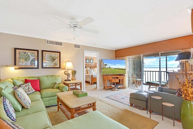 living room with a textured ceiling, light tile patterned flooring, and ceiling fan