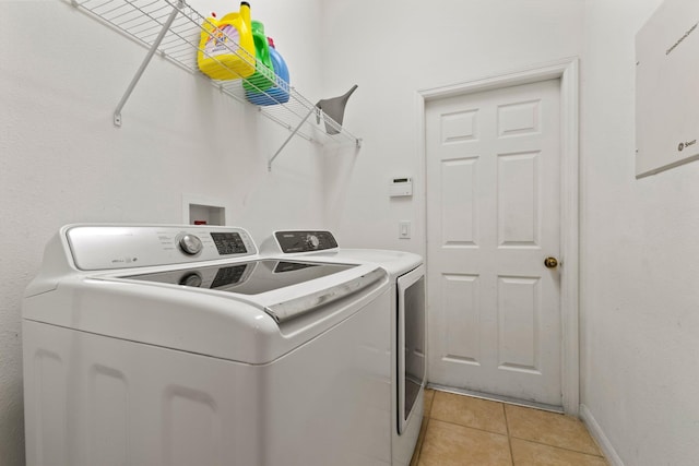 laundry area featuring independent washer and dryer and light tile patterned flooring