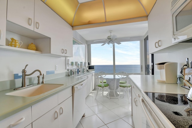 kitchen featuring white cabinets, ceiling fan, light tile patterned floors, sink, and white appliances