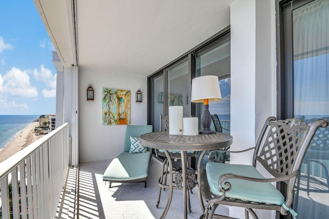 balcony featuring a water view and a beach view