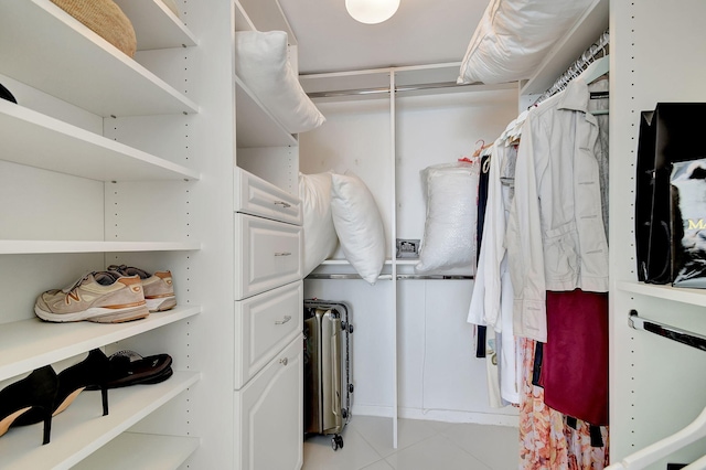 walk in closet with light tile patterned floors