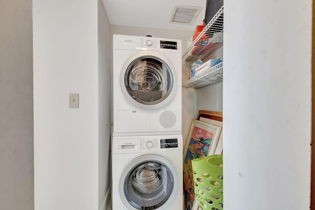 clothes washing area with stacked washer and dryer