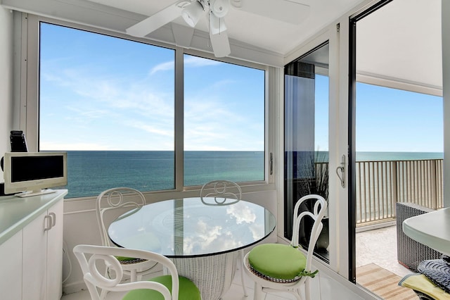 sunroom / solarium featuring a water view, ceiling fan, and plenty of natural light