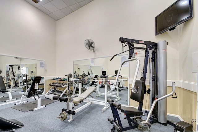 workout area with a towering ceiling and a drop ceiling