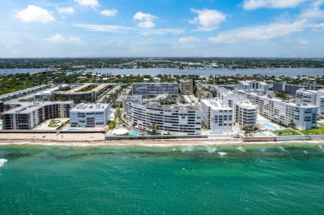 birds eye view of property with a water view and a beach view