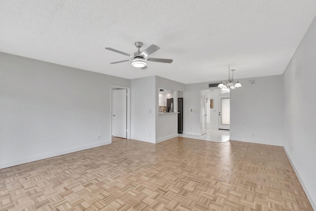 spare room with light parquet flooring, a textured ceiling, and ceiling fan with notable chandelier