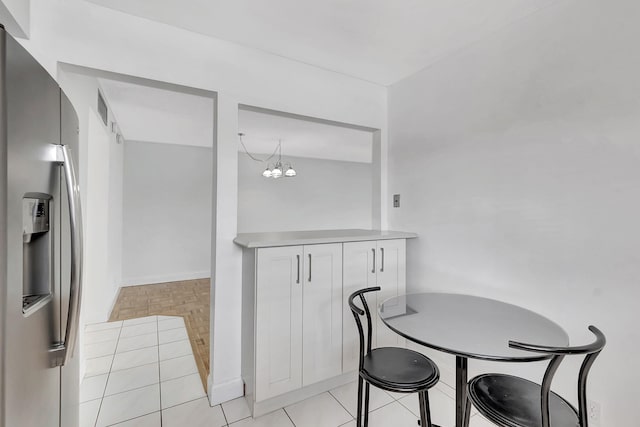 dining space with a notable chandelier and light tile patterned floors