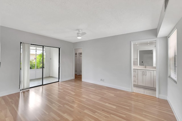 unfurnished room featuring light hardwood / wood-style floors, a textured ceiling, and ceiling fan