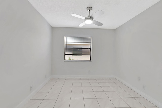 tiled empty room featuring a textured ceiling and ceiling fan