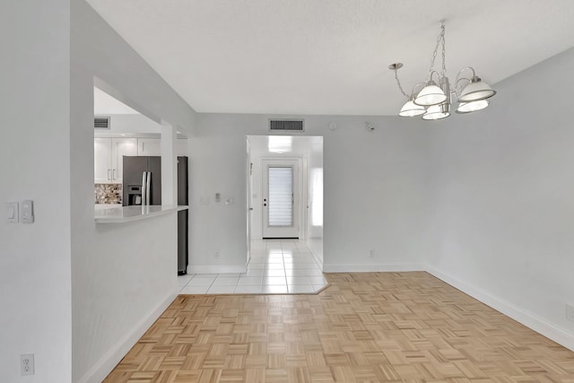 empty room featuring a textured ceiling and light parquet floors