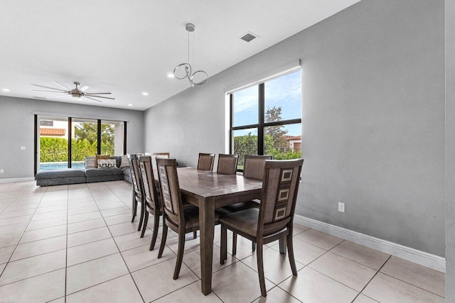 dining space with light tile patterned floors and ceiling fan with notable chandelier