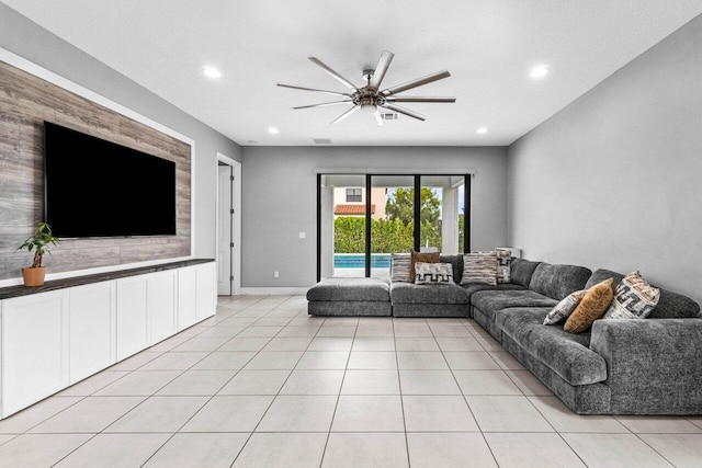 unfurnished living room featuring ceiling fan, light tile patterned floors, and a textured ceiling