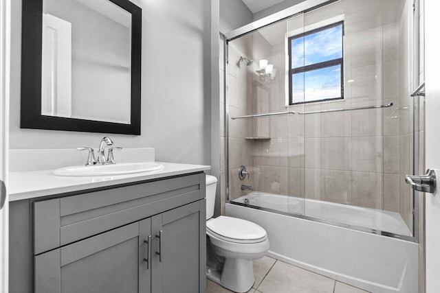 full bathroom featuring tile patterned flooring, vanity, toilet, and shower / bath combination with glass door