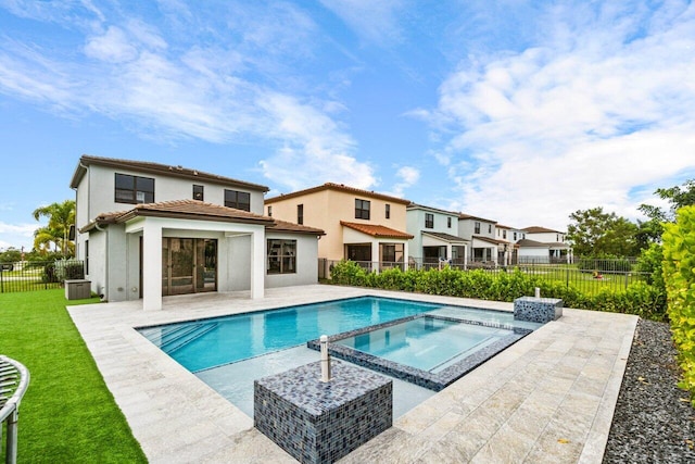 view of pool with an in ground hot tub, a yard, a patio, and central AC unit