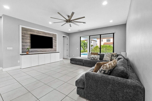 living room with light tile patterned floors, a textured ceiling, and ceiling fan