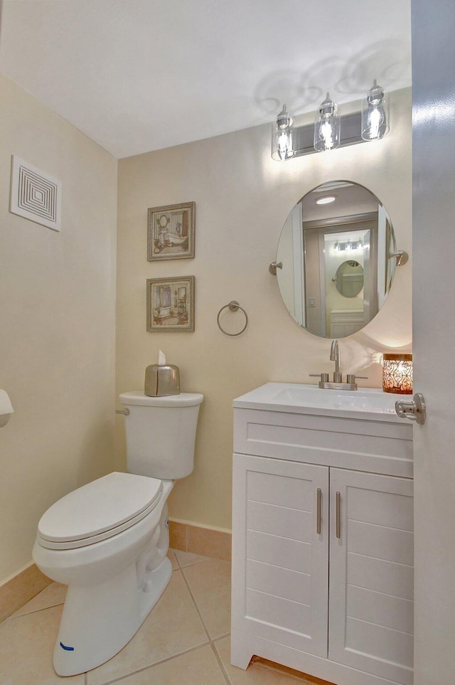 bathroom with toilet, vanity, and tile patterned flooring