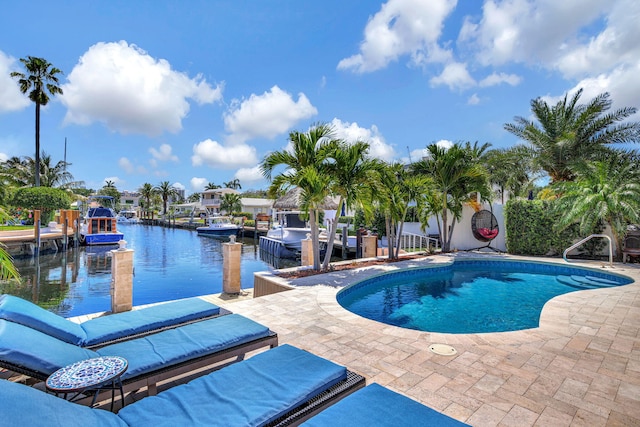 view of swimming pool with a water view, a patio area, and a dock