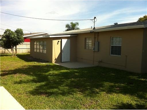 back of property featuring a lawn