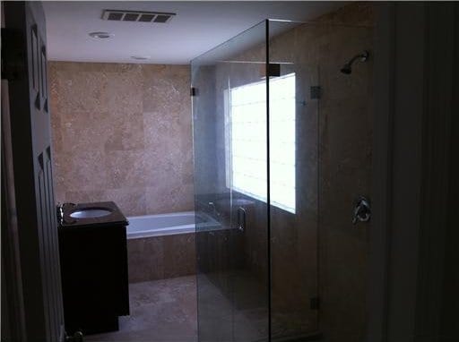 bathroom featuring vanity and plus walk in shower