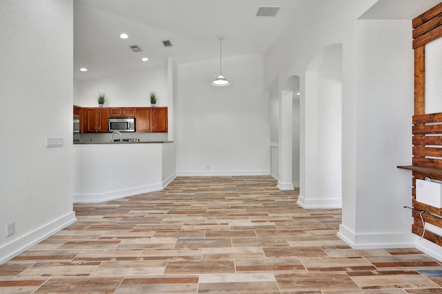 unfurnished living room featuring lofted ceiling and light hardwood / wood-style flooring