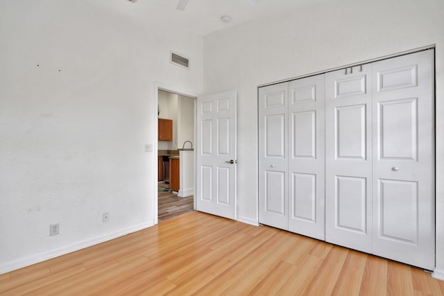 unfurnished bedroom with light wood-type flooring and a closet