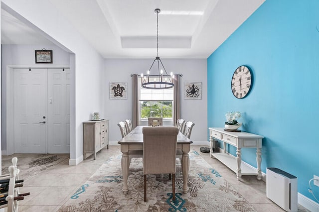 dining area with a notable chandelier and a tray ceiling