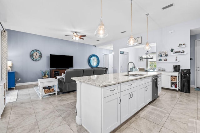 kitchen with a center island with sink, sink, decorative light fixtures, white cabinets, and light stone counters