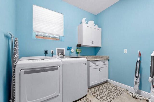 washroom with washer and dryer, cabinets, and light tile patterned floors