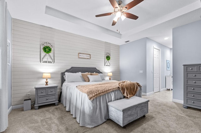 carpeted bedroom featuring wood walls and ceiling fan