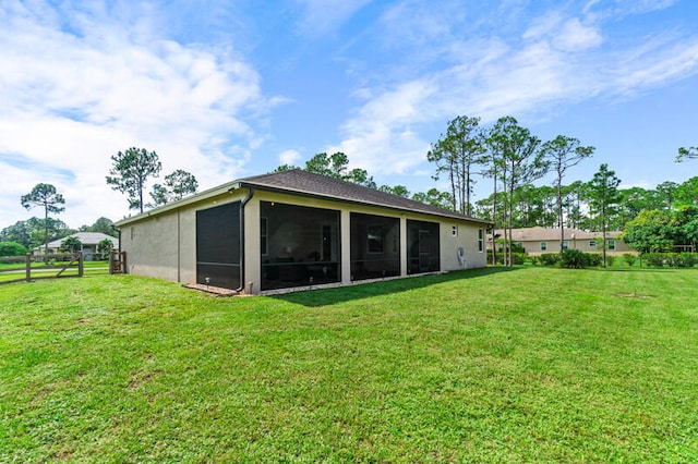 back of property featuring a yard and a sunroom